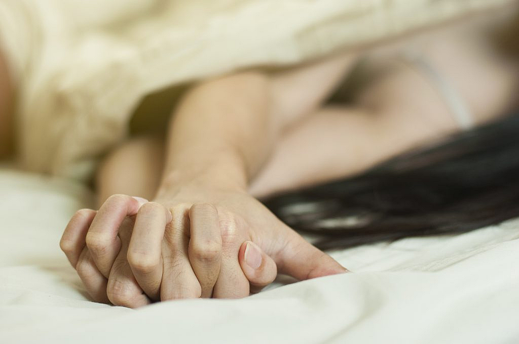 Close up hands of a couple make love hot sex on a bed