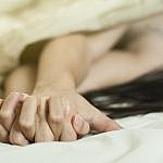 Close up hands of a couple make love hot sex on a bed