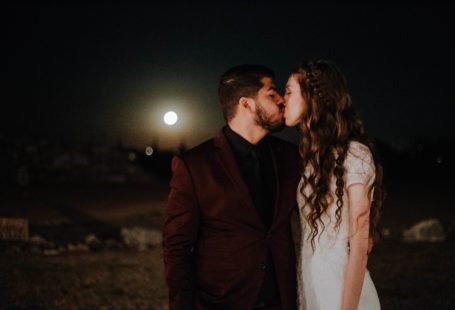 A couple is kissing when it's full moonlight
