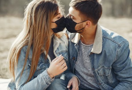 young couple wearing masks and kissing