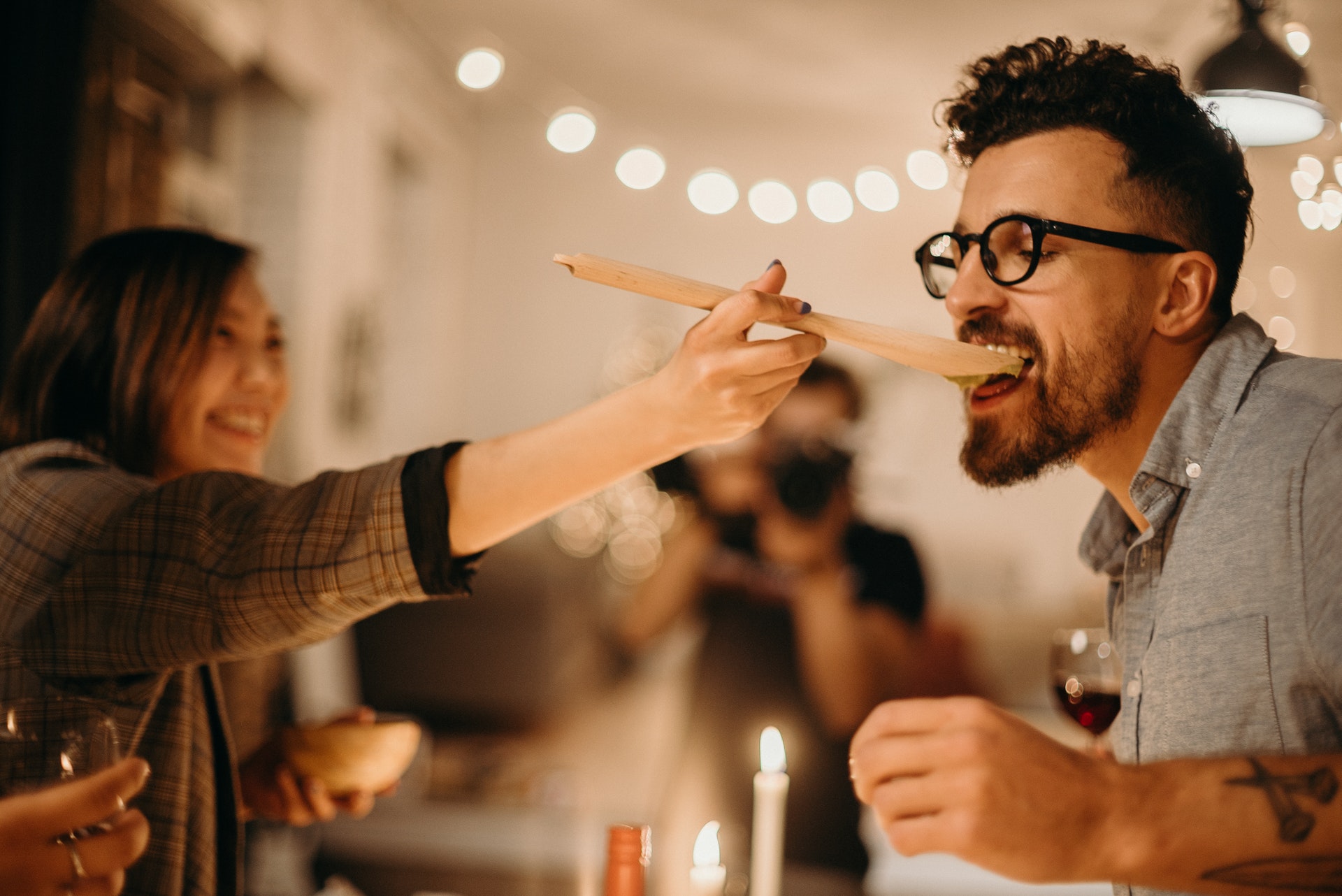 woman holding ladle feeding man