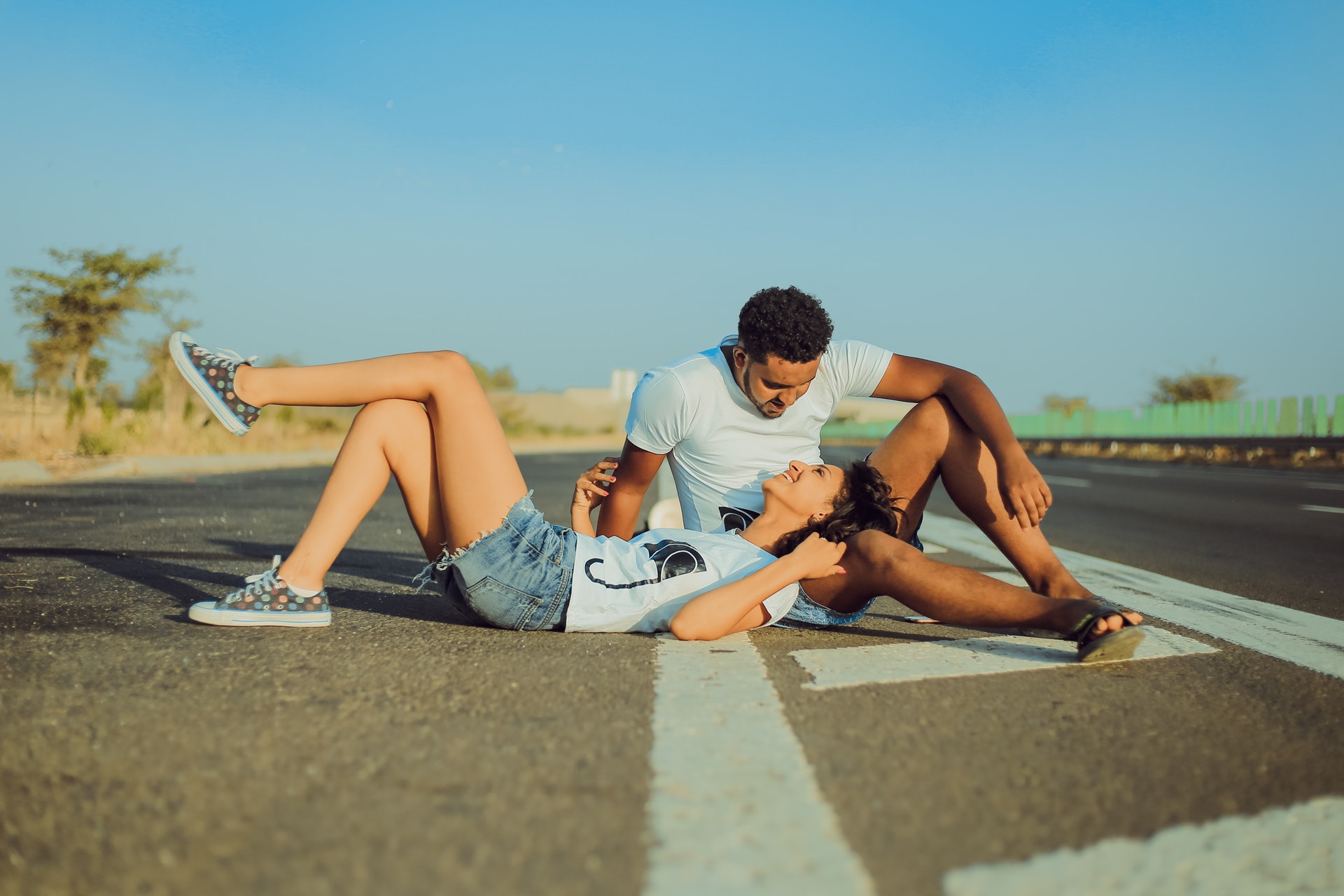 a woman laying on the road on a man's lap