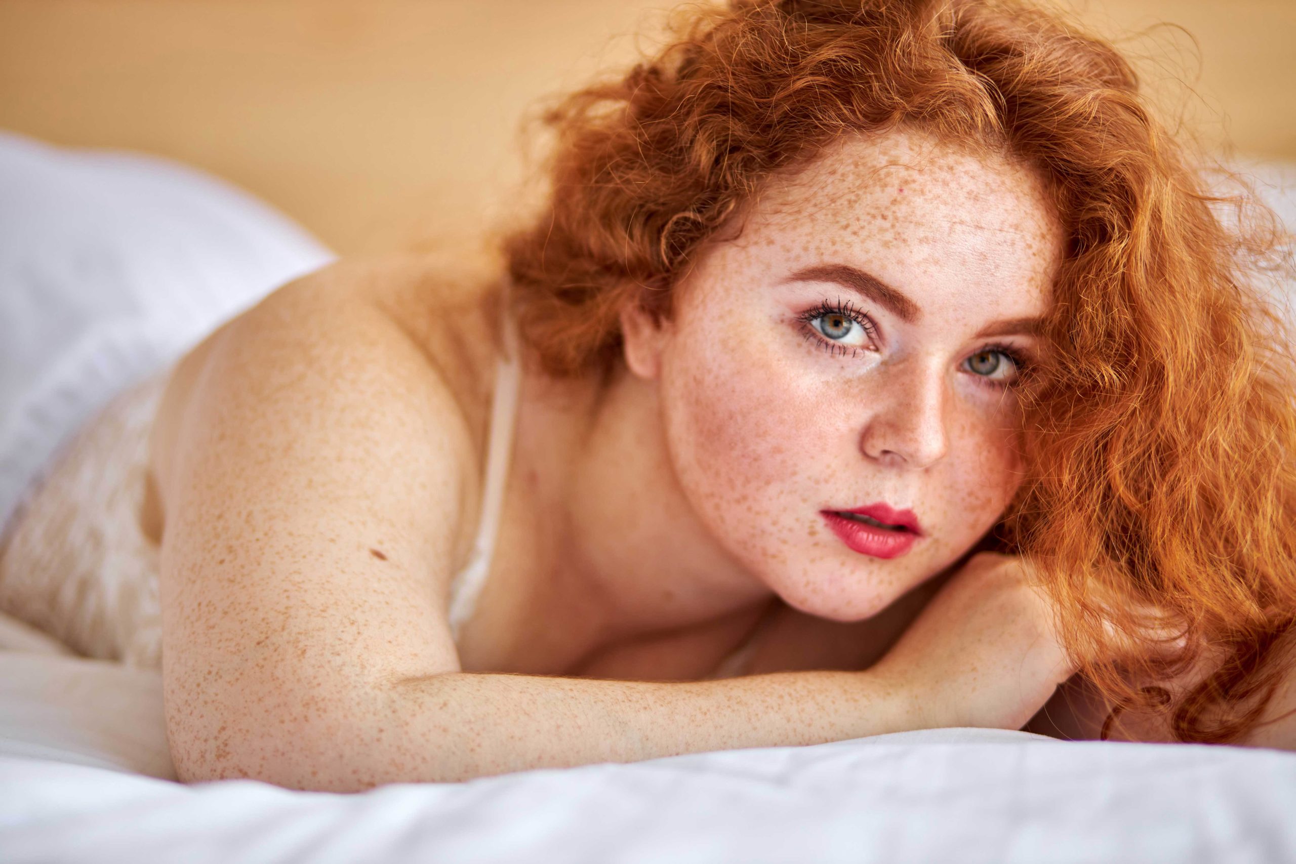 BBW overweight pretty caucasian woman showing off fat figure wearing sexy lingerie, lying on bed relaxing, sexy redhead female at home