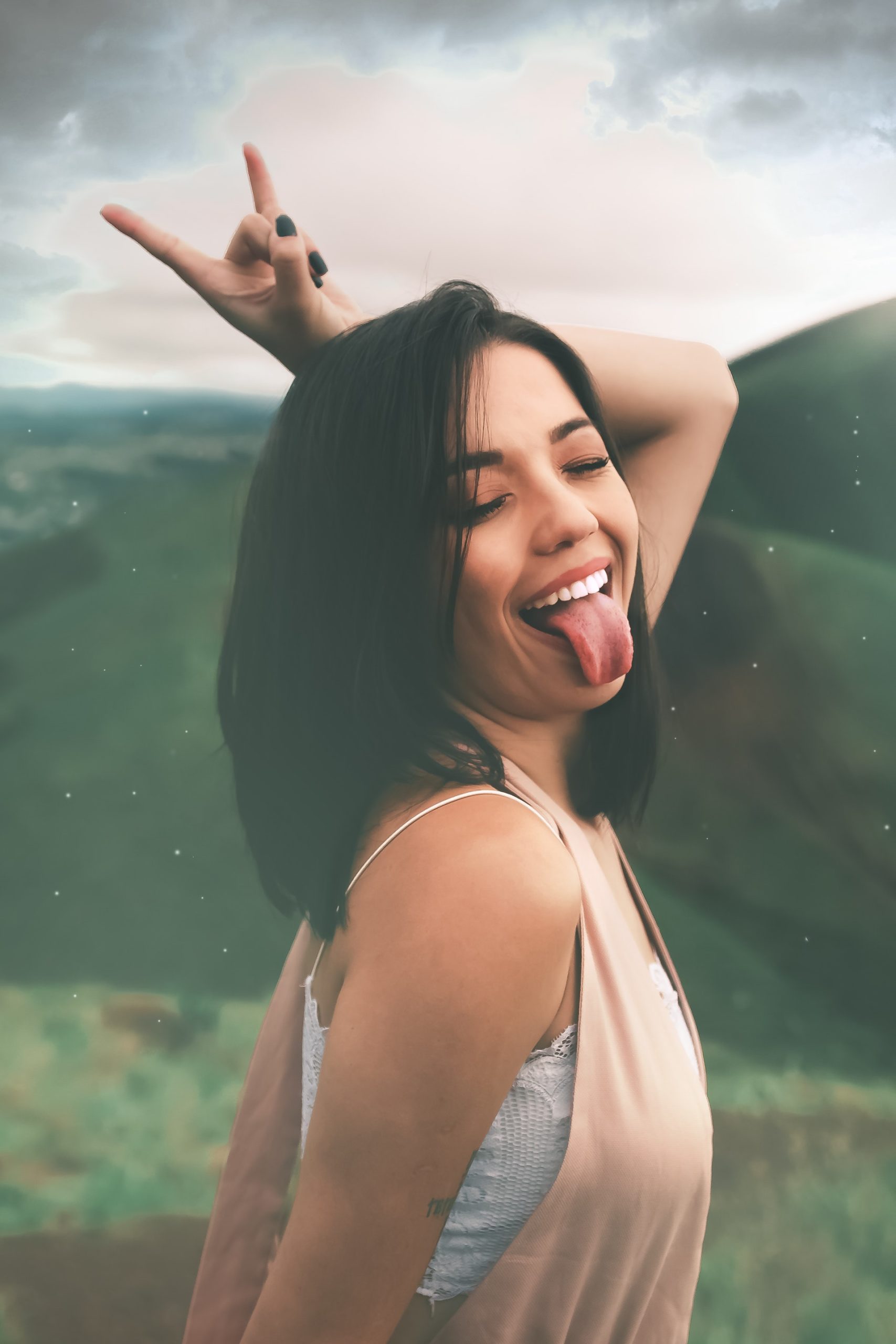 woman in white tank top doing silly crazy gesture and smile happily