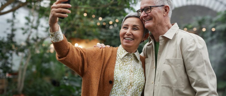 senior couple smiling while taking a sefie