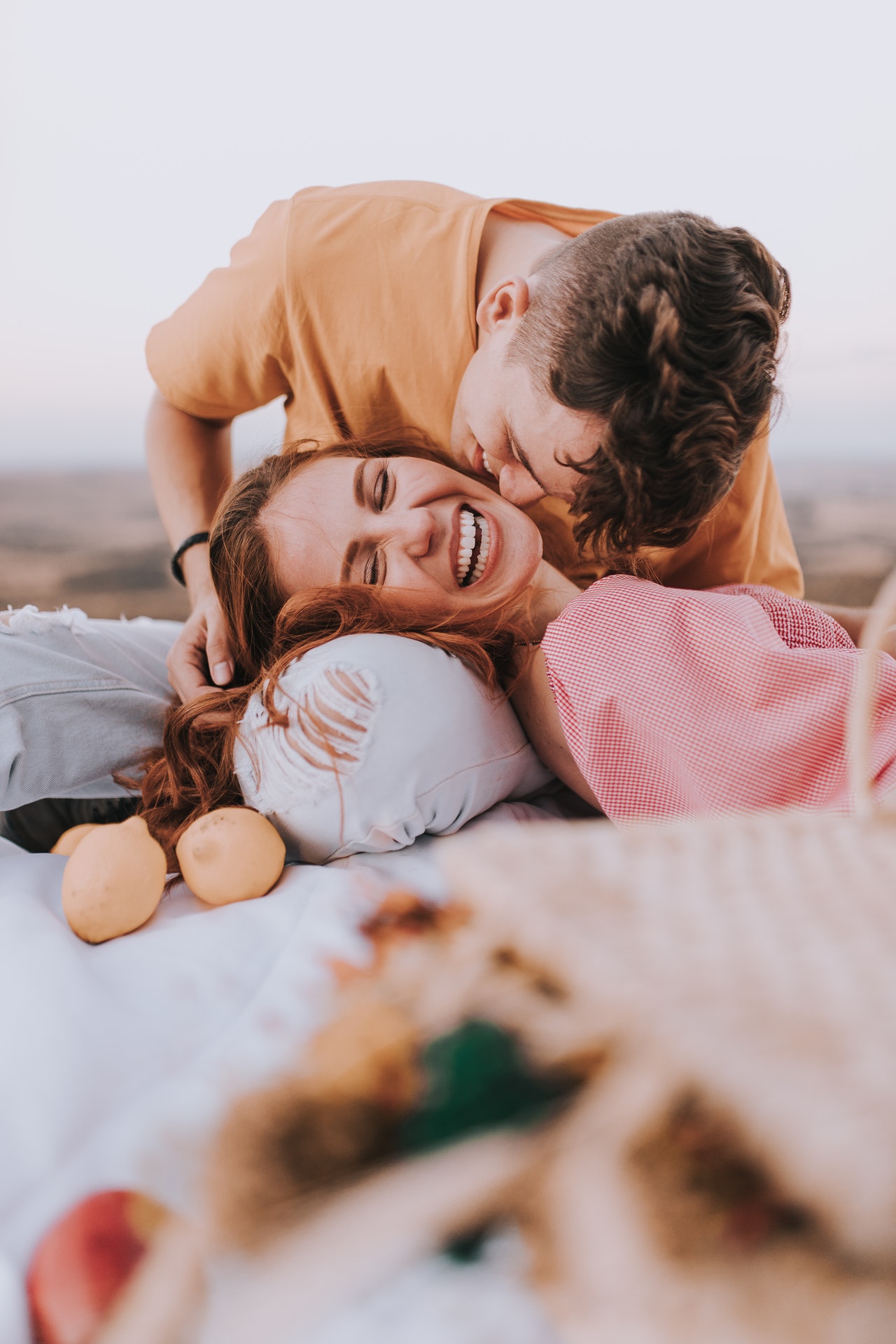 a happy couple in love with a woman smile happily while her boy friend kiss her cheek