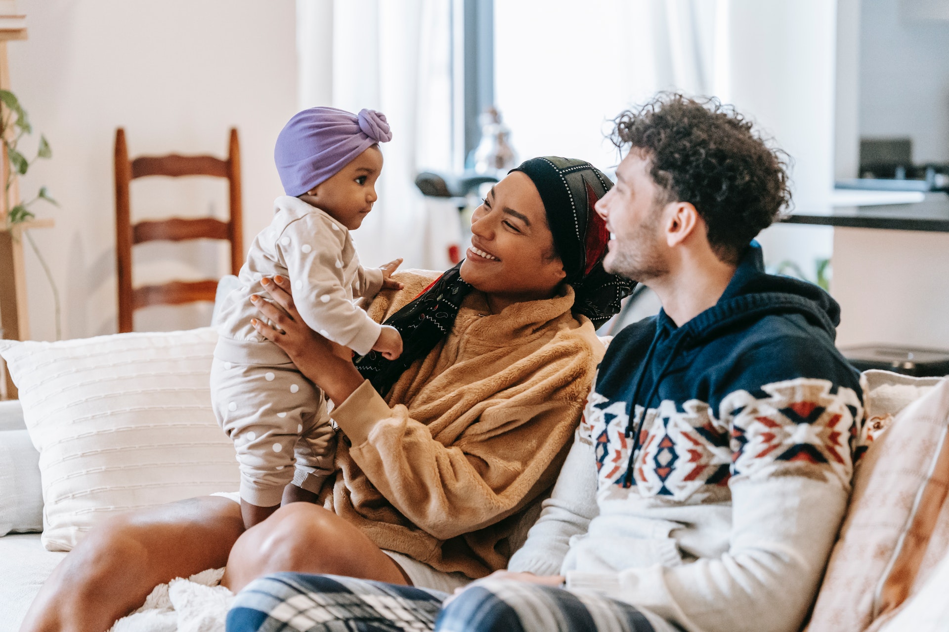 delight single parent with her boy friend sitting on sofa with cute baby