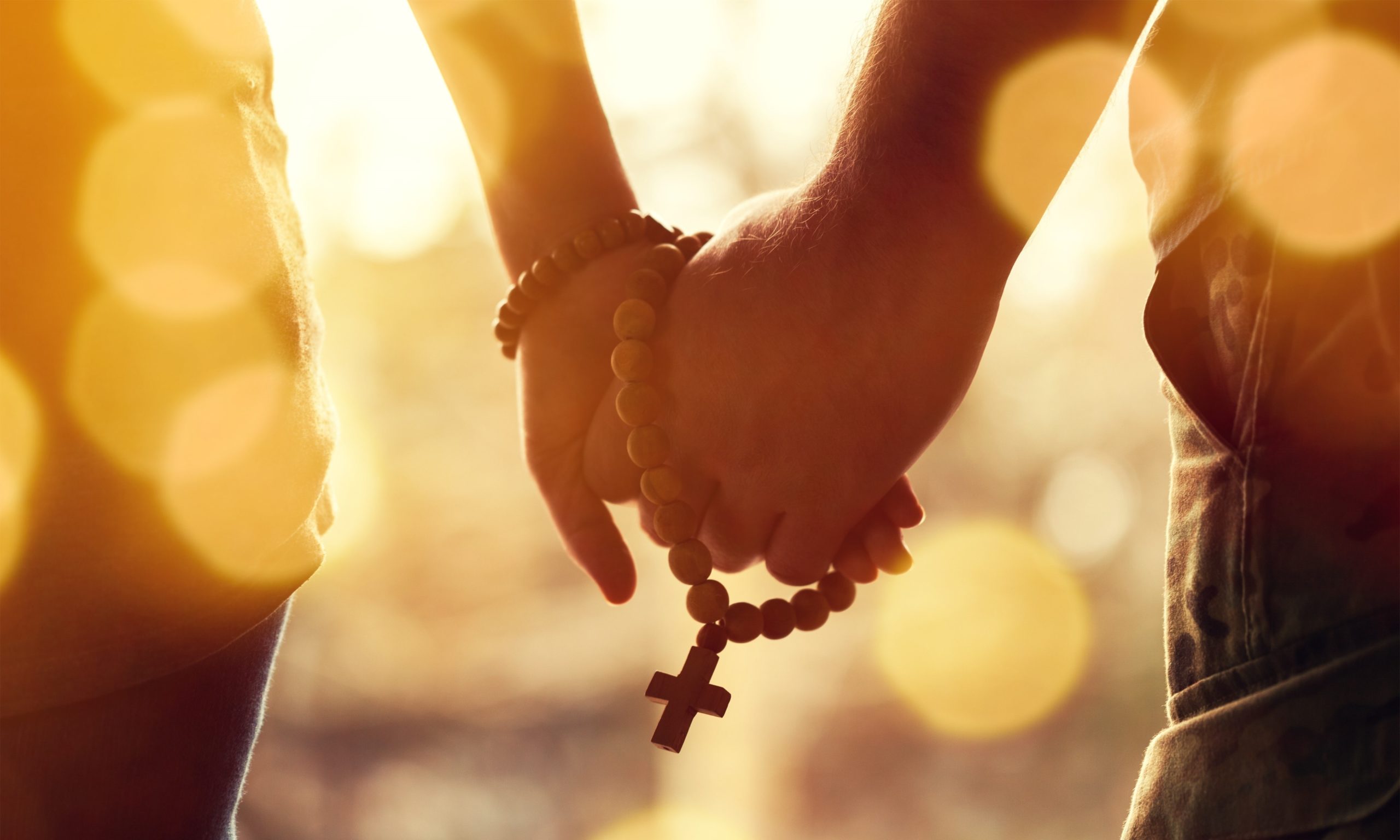 Christian Dating Couple praying together. Holding rosary in hand.