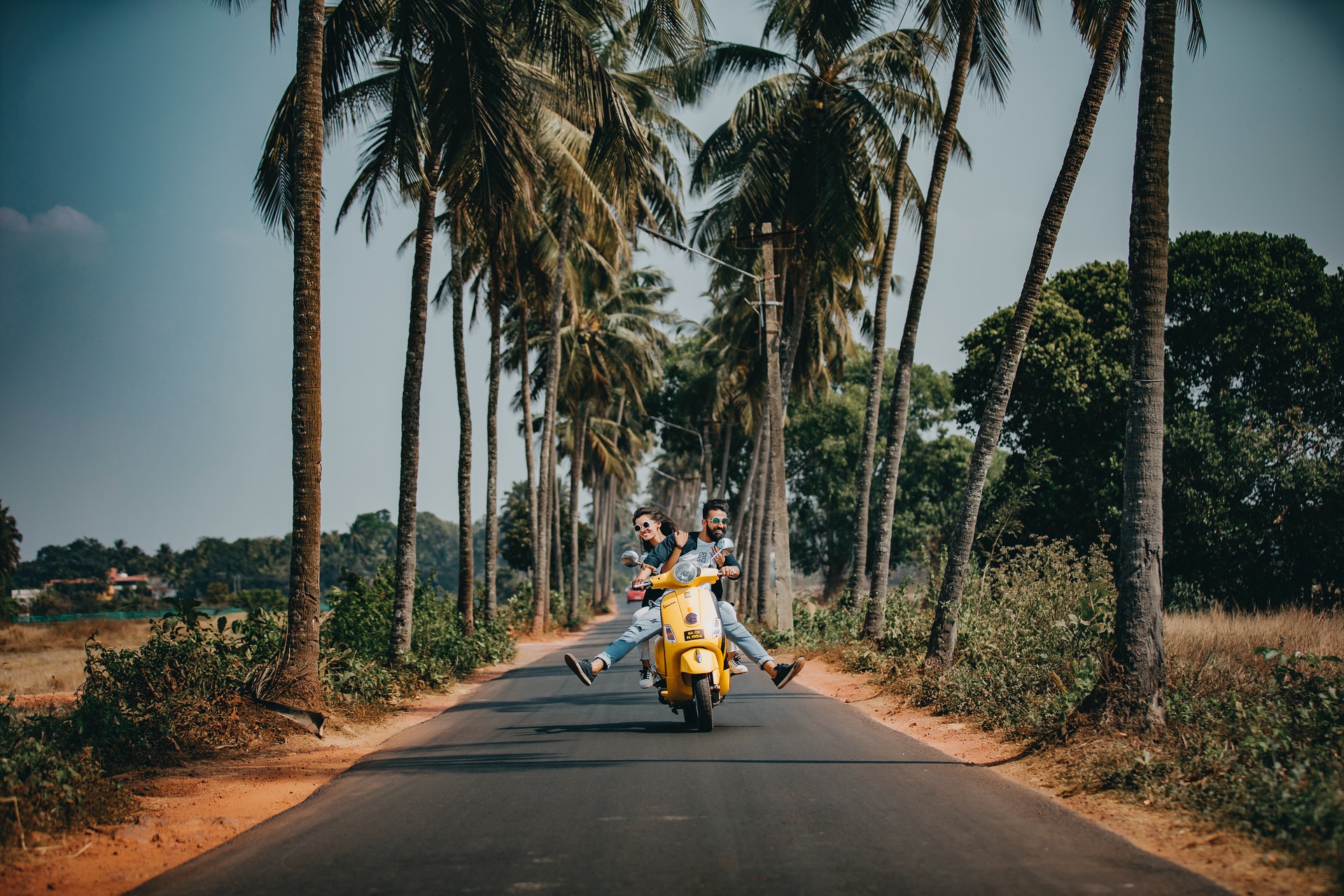 a woman and a man riding on a motobike