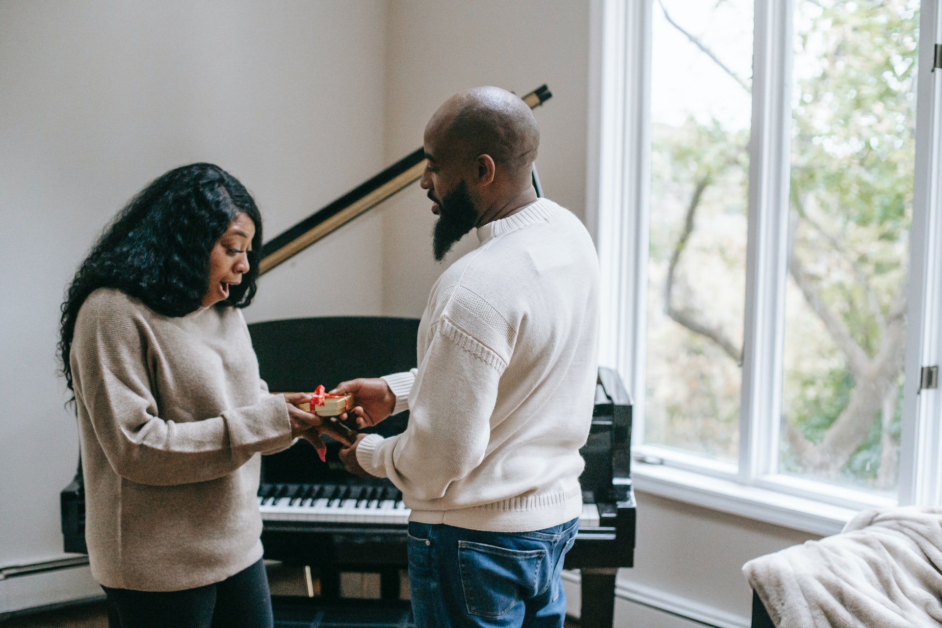 a black man giving gift to a black woman