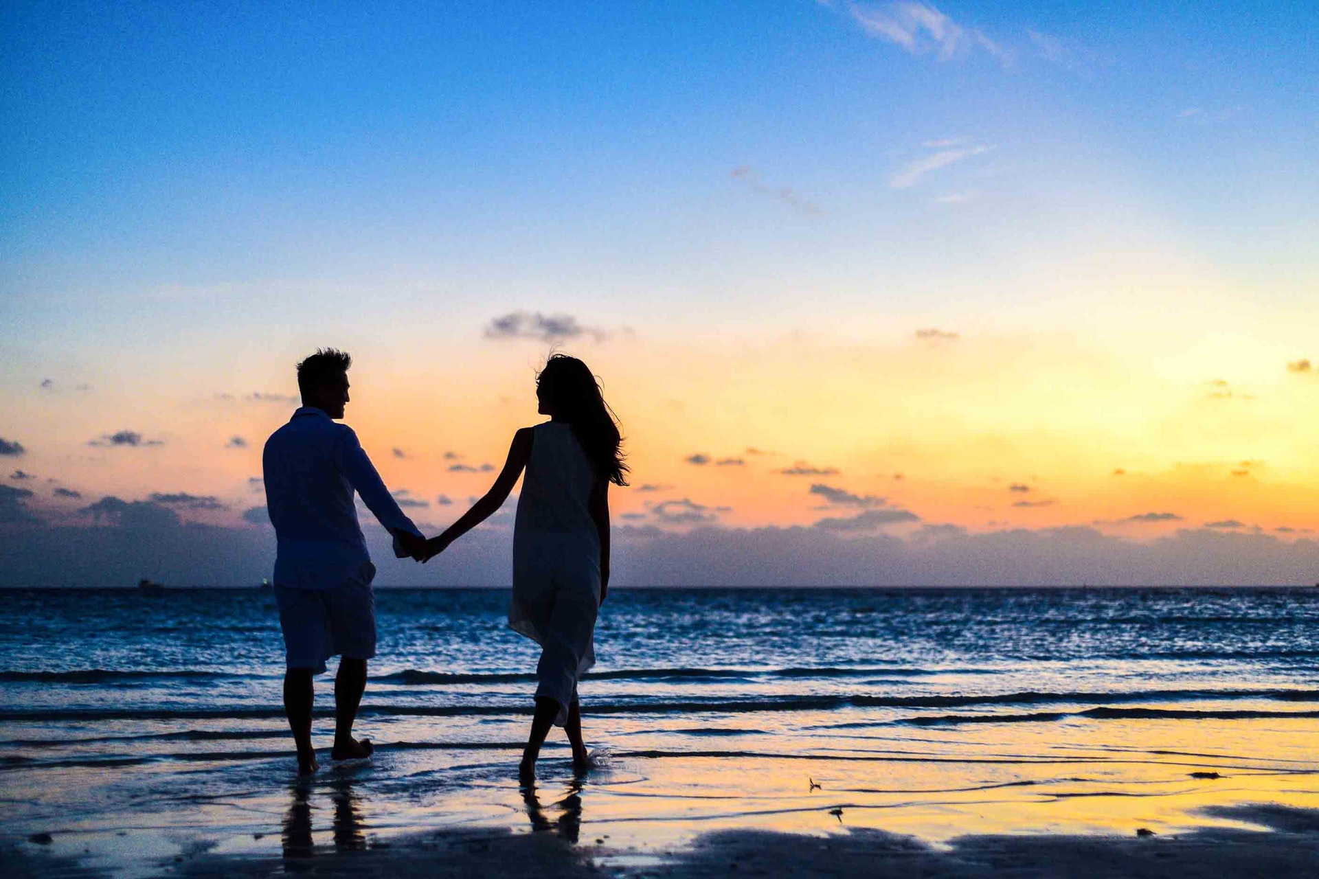 divorced single man and woman holding hand by the beach