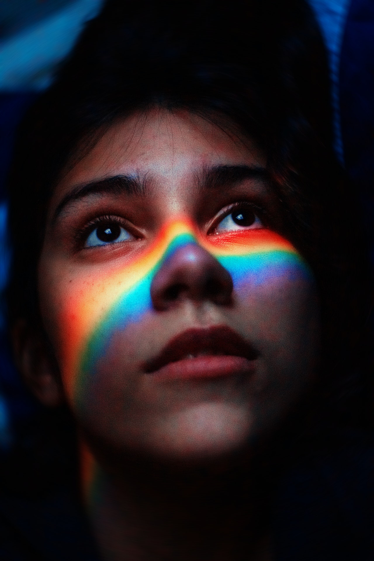 a close up photo of a lesbian girl face in shadow of LGBT rainbow color