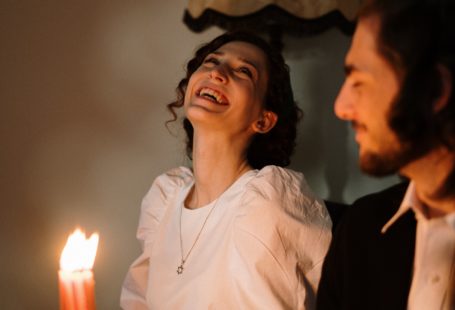 a happy woman in white shirt dating a Jewish man by candles