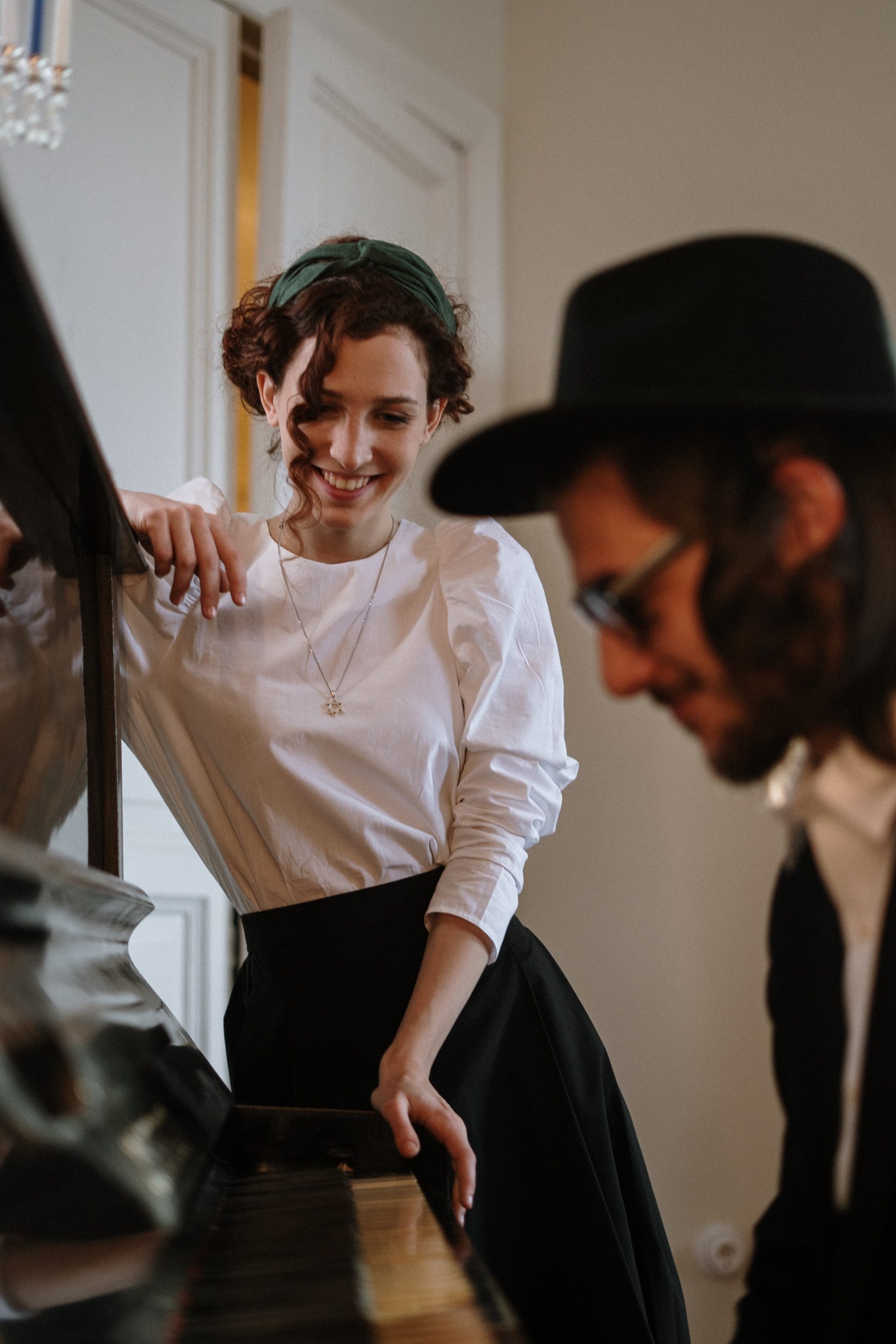 a woman in white shirt dating a Jewish man who is playing a piano