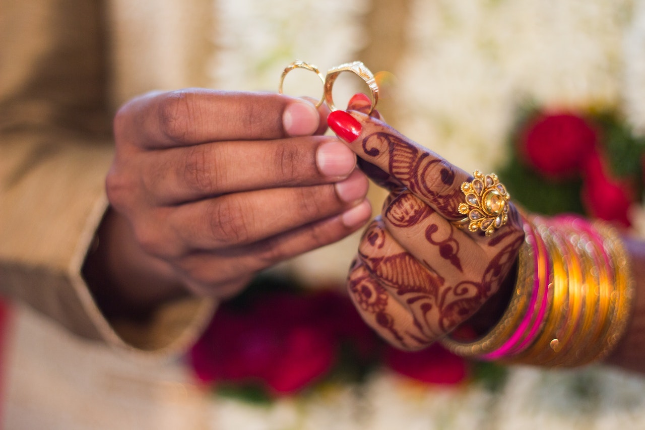 hands of a Hindu man and a woman holding wedding rings