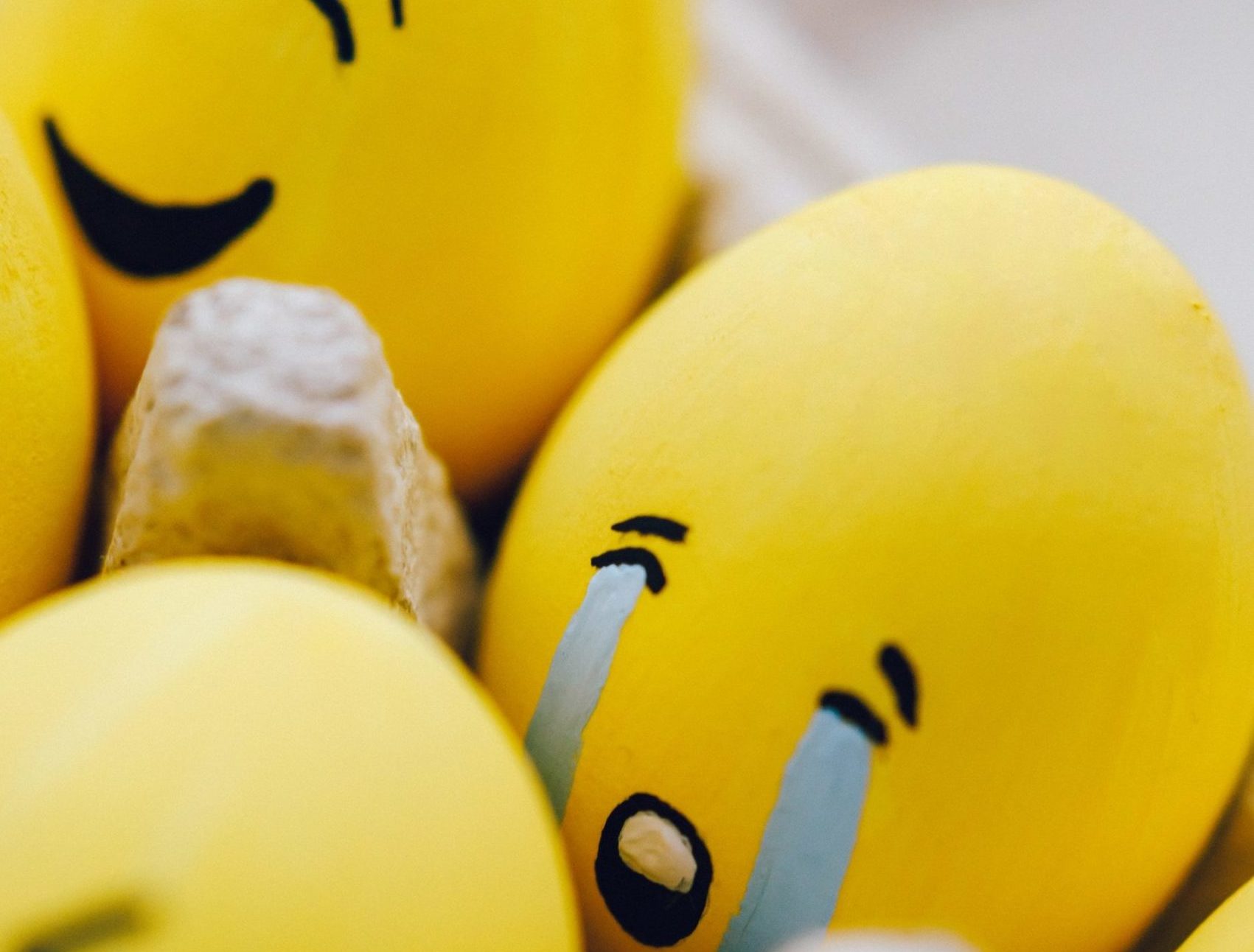 yellow painted sad and happy faces on eggs