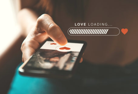 Love loading progress, Finger of woman pushing heart icon on screen in mobile smartphone application. Online dating app, valentine's day concept.