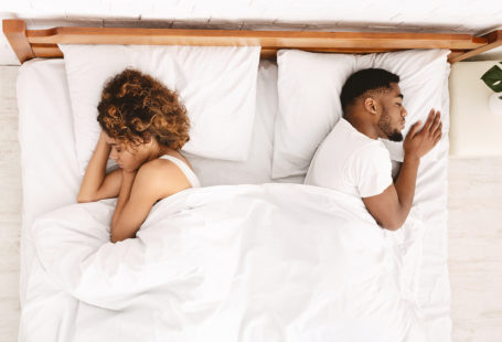 couple sleep separately on bed, partner doesn't want to be intimate