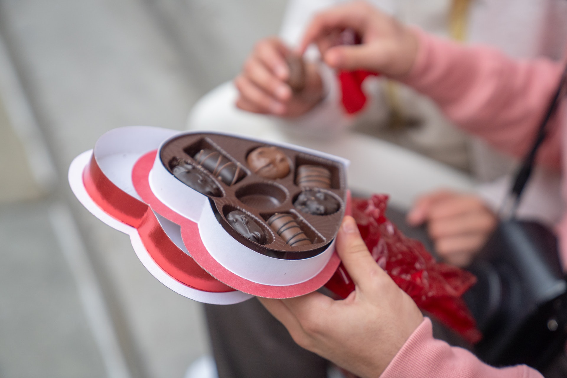 a guy giving a box of chocolate for a woman