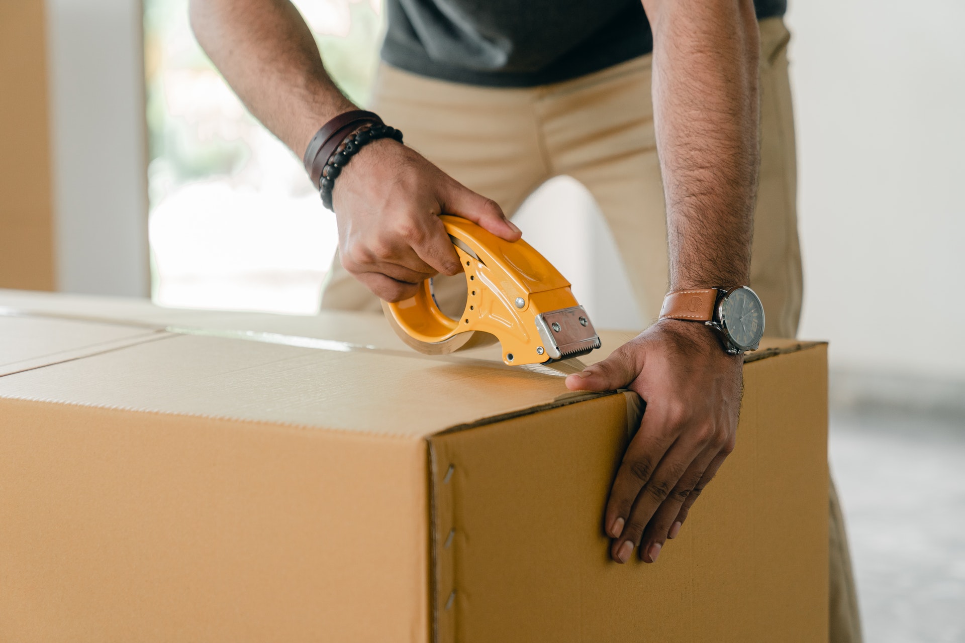 a man taping box with scotch, pack to move on